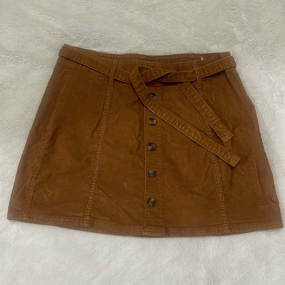 Brown skirt about mid-thigh,Cute with black boots, black bodysuit underneath.
